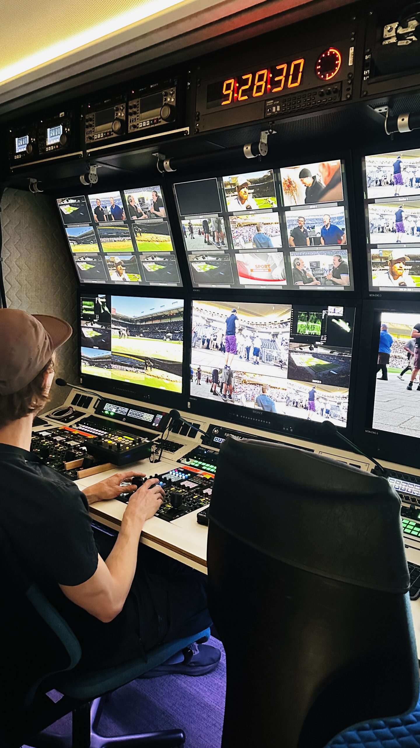 Techniker steuert im Übertragungswagen mehrere Bildschirme während der Live-Berichterstattung vom Schwingfest